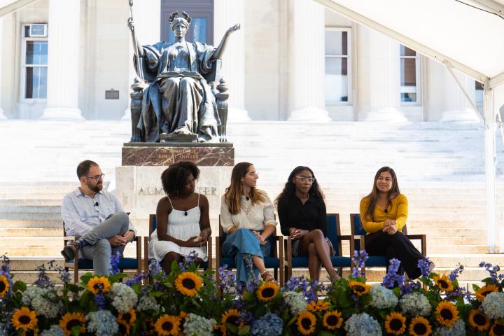 Students on panel in front of Alma Mater.