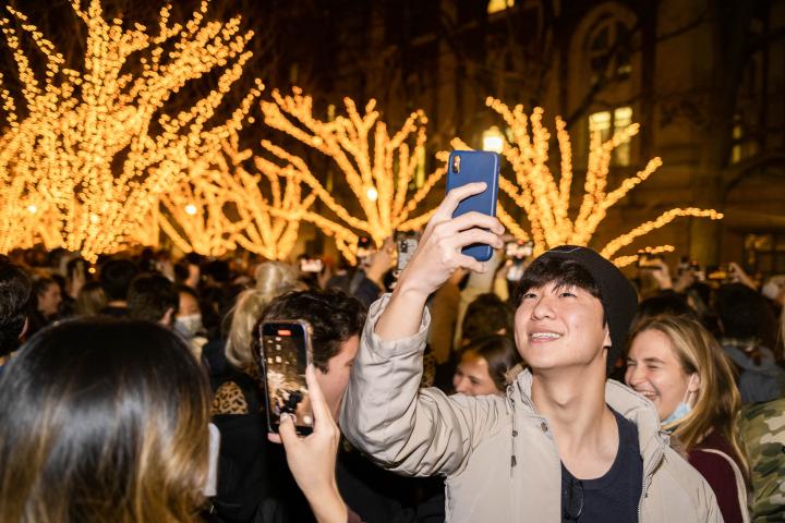 Students taking pictures at the College walk Tree Lighting.