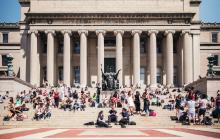 Students gathered under illuminated trees on Columbia's College Walk