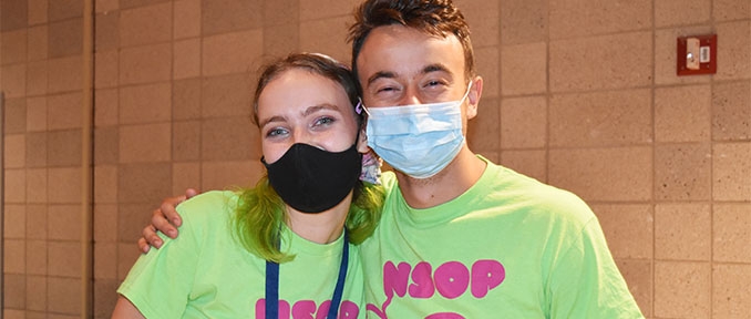 Two students wearing masks and NSOP shirts pose together