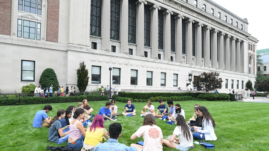 Students at Orientation sit on South Lawn with Butler Library in the background